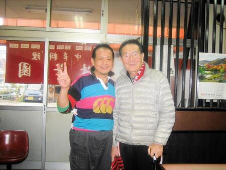 経営する中華料理店の前で山口良治さん（右）と撮影する清水さん