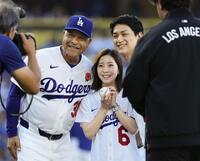 　始球式を終え、ドジャースのロバーツ監督（左）と記念写真に納まるフィギュアスケート・ペアの三浦璃来さん（中央）と木原龍一さん＝ロサンゼルス（共同）