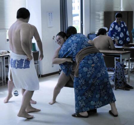 大森（手前左）ら授業後の休み時間は空いたスペースで相撲を取る教習生