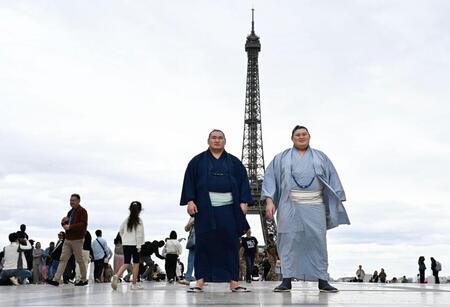 大相撲パリ公演を前に、エッフェル塔の前で写真に納まる大の里（右）と豊昇龍の両横綱＝11日、パリ（共同）