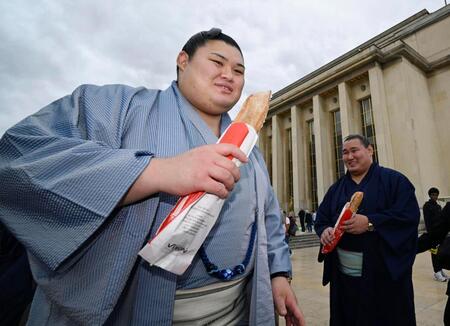 大相撲パリ公演を前に、フランスパンを手に笑顔を見せる大の里（左）と豊昇龍の両横綱＝11日、パリ（共同）
