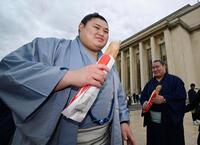 大相撲パリ公演を前に、フランスパンを手に笑顔を見せる大の里（左）と豊昇龍の両横綱＝11日、パリ（共同）