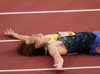 優勝し、笑顔で倒れ込む泉谷駿介＝１４日