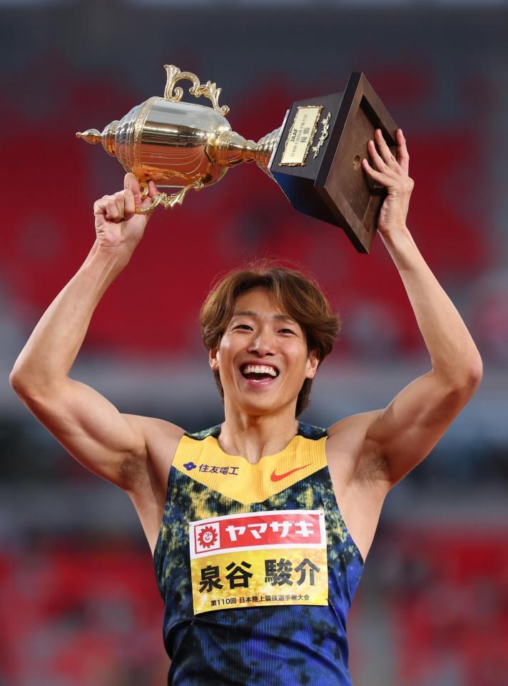 優勝しトロフィーを掲げ笑顔を見せる泉谷駿介＝１４日
