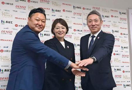 　ポーズをとるアイスホッケー女子日本代表の大久保智仁新監督（右）と、久保英恵新コーチ（中央）ら＝１９日、東京都内