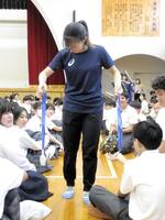 母校の渚中学校での交流会で１人１人にミラノ・コルティナ五輪で獲得したメダルを触ってもらう坂本さん（撮影・高橋伯弥）