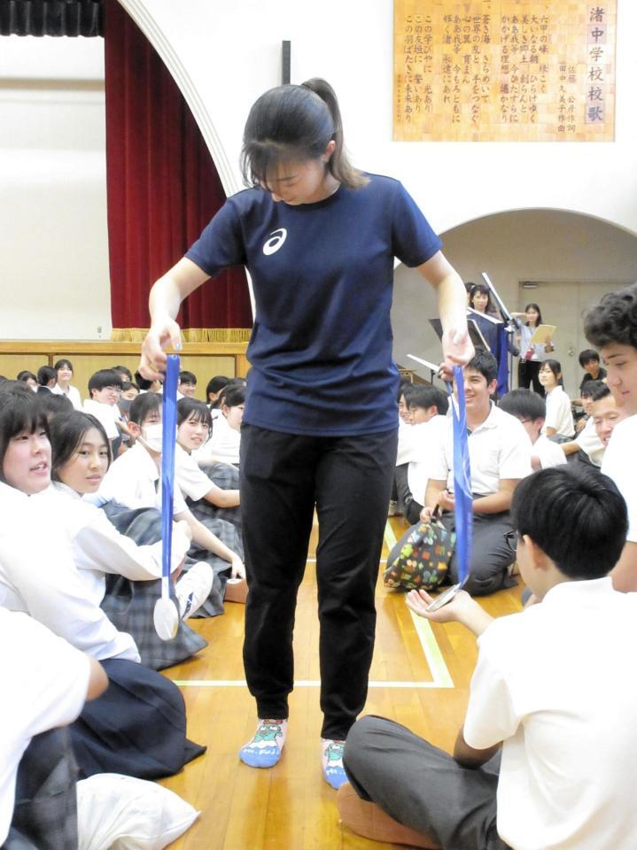 母校の渚中学校での交流会で１人１人にミラノ・コルティナ五輪で獲得したメダルを触ってもらう坂本さん（撮影・高橋伯弥）