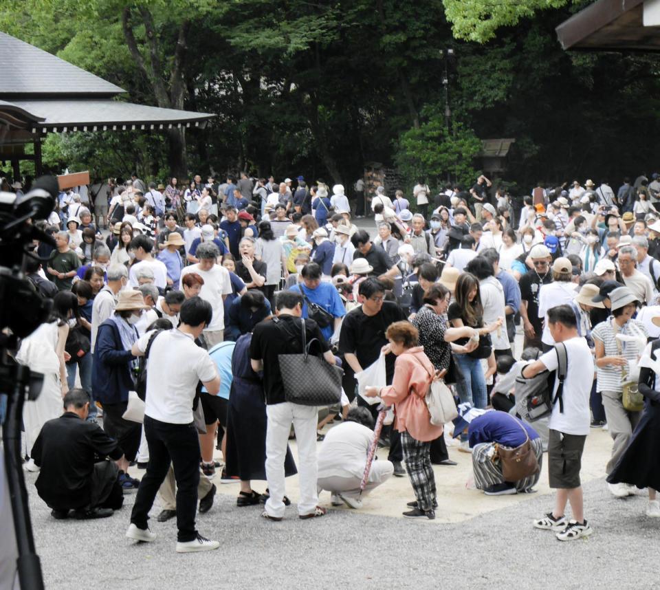 横綱土俵入り用に敷き詰められた砂を拾い集める来場者＝熱田神宮