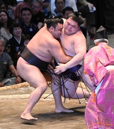 霧島（左）が厳しく攻め、すくい投げで王鵬を下す