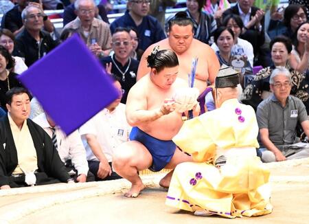 座布団が舞う中、懸賞の束を受け取る藤ノ川