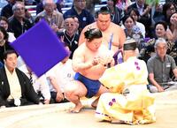 座布団が舞う中、懸賞の束を受け取る藤ノ川