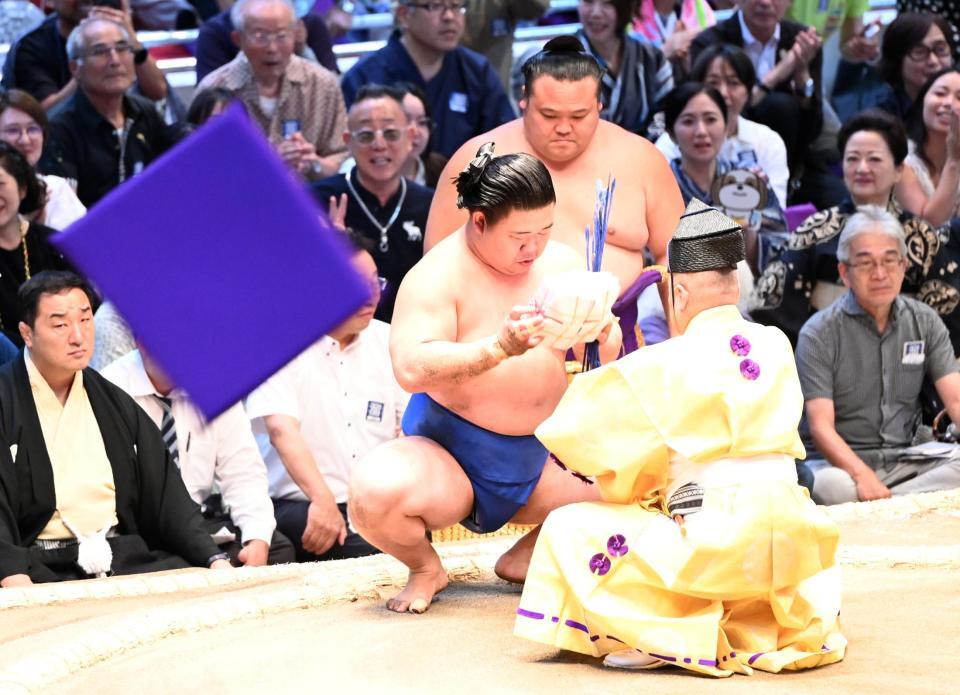 座布団が舞う中、懸賞の束を受け取る藤ノ川