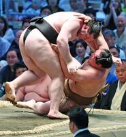 獅司（左）がすくい投げで竜電を下す