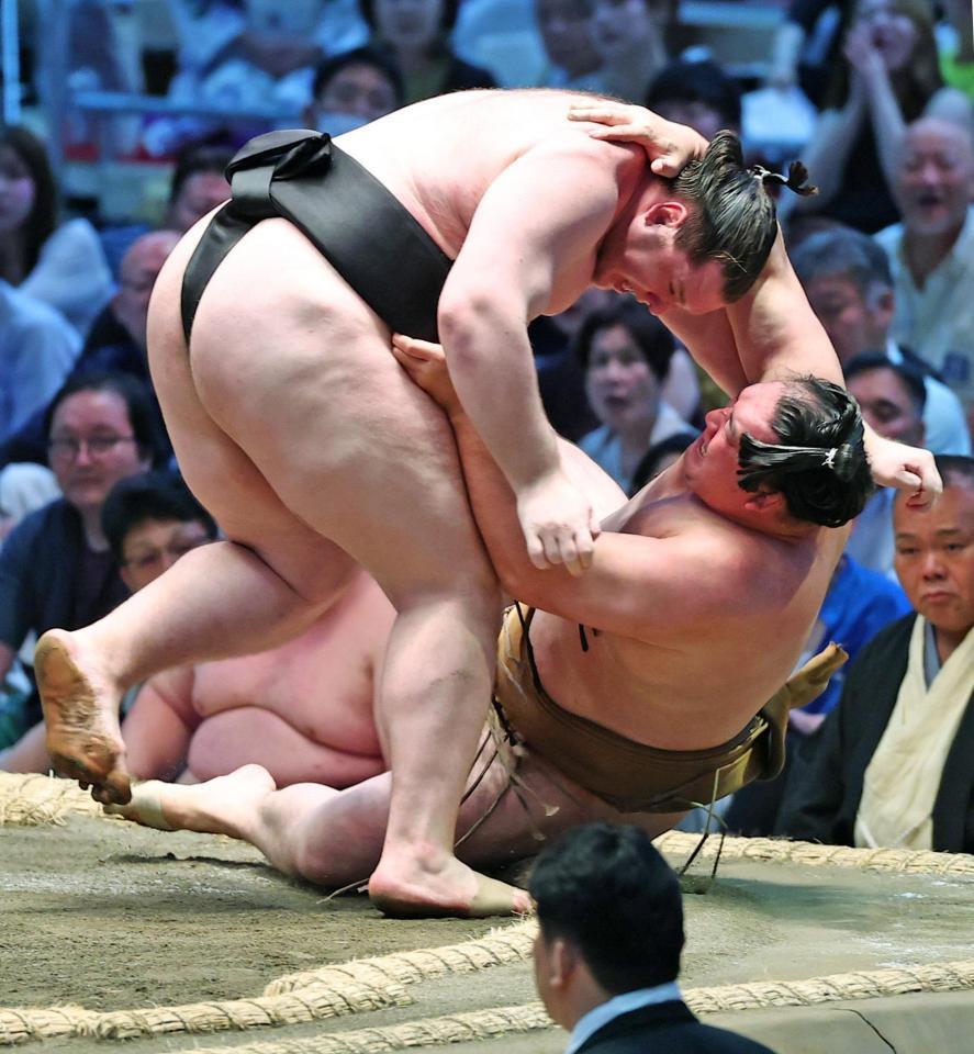 獅司（左）がすくい投げで竜電を下す
