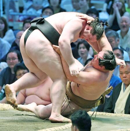 獅司（左）がすくい投げで竜電を下す