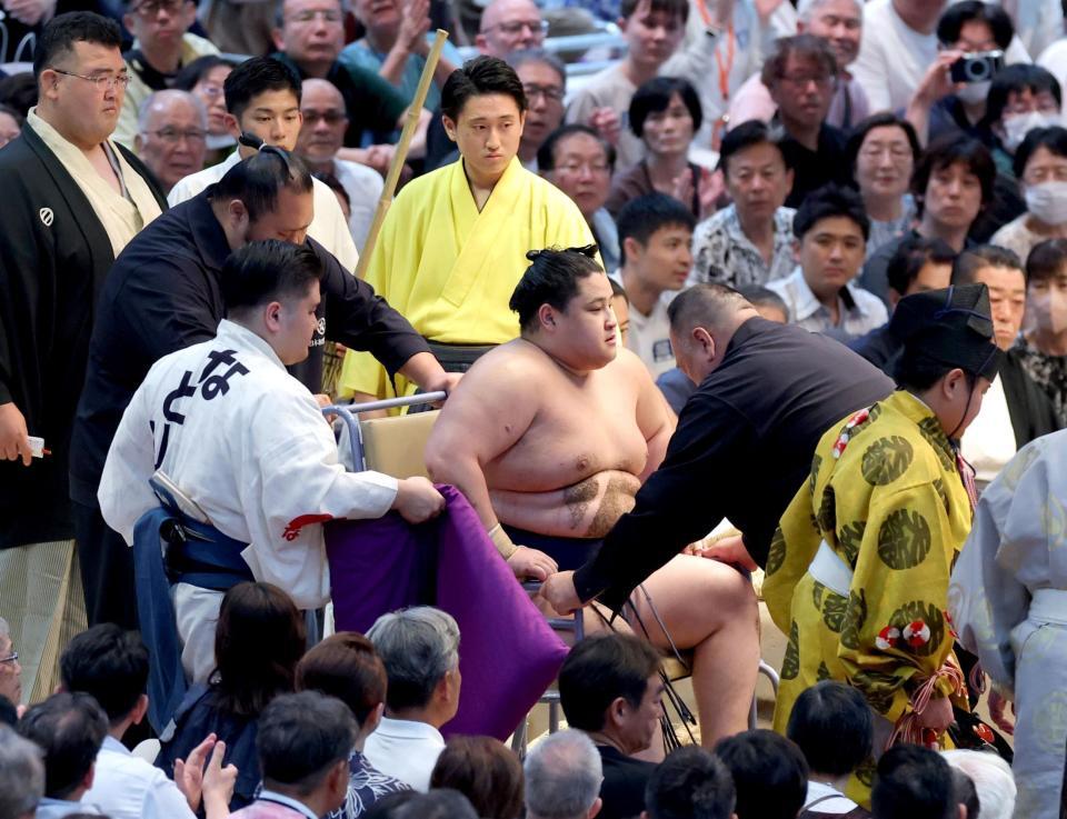 車いすに乗せられ花道を引き揚げる若ノ勝（撮影・立川洋一郎）