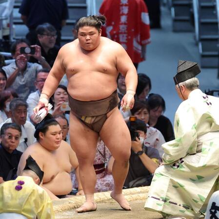 豊昇龍から金星を挙げ懸賞金を手に土俵を降りる伯乃富士（撮影・立川洋一郎）