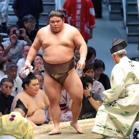 豊昇龍から金星を挙げ懸賞金を手に土俵を降りる伯乃富士（撮影・立川洋一郎）