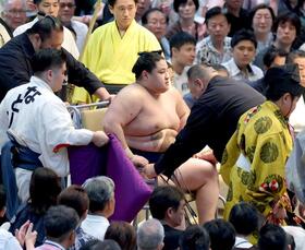 　車いすに乗せられ花道を引き揚げる若ノ勝（撮影・立川洋一郎）