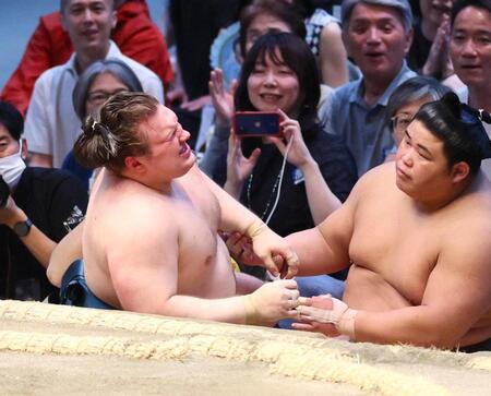 隆の勝を押し出しで下し、土俵下に落ちた安青錦。右は伯乃富士