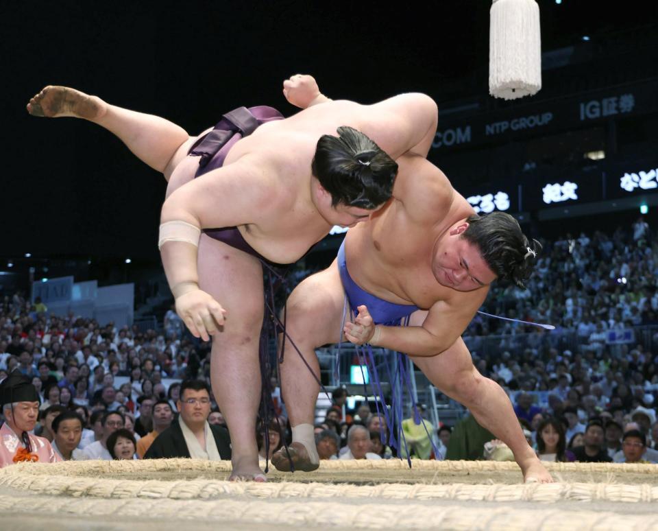 藤ノ川（右）がすくい投げで王鵬を破る