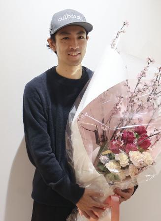 現役最後のレースを終えて帰国し、花束を手に写真に納まるノルディックスキー複合男子の渡部暁斗＝３月、羽田空港