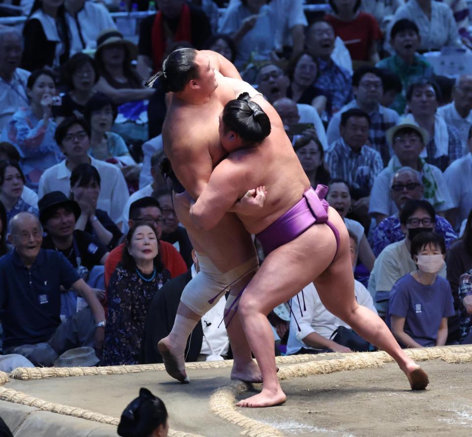 朝乃山（左）を寄り切る尊富士（撮影・佐々木彰尚）