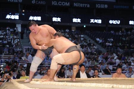 栃清龍（左）を寄り切りで下す行徳（撮影・佐々木彰尚）