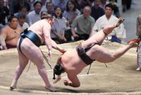 安青錦（左）が肩透かしで霧島を破る