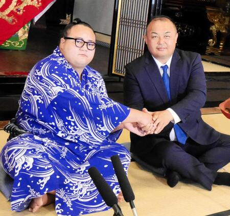 　新十両昇進が決まり、荒汐親方（右）と握手を交わす丹治（撮影・山本鋼平）