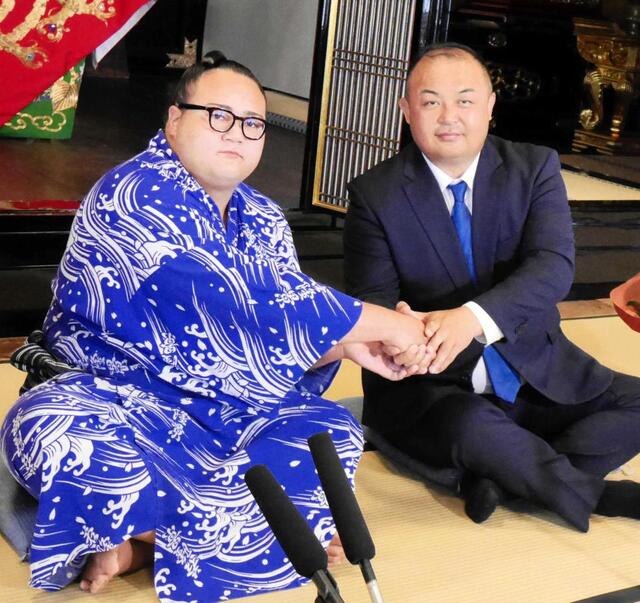 　新十両昇進が決まり、荒汐親方（右）と握手を交わす丹治（撮影・山本鋼平）