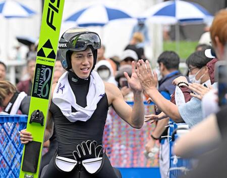 　２回目の飛躍を終え観客とタッチを交わす二階堂蓮。男子成年で優勝した
