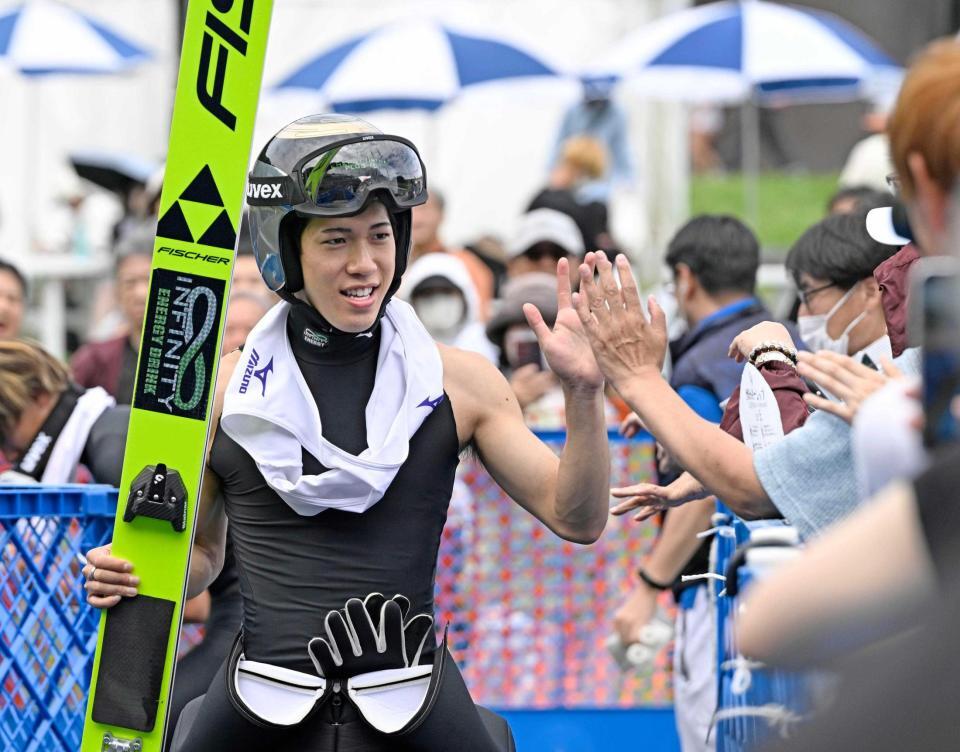　２回目の飛躍を終え観客とタッチを交わす二階堂蓮。男子成年で優勝した