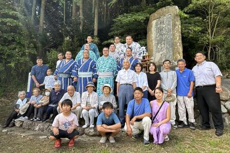 　横綱阿武松の石碑の前で記念撮影する阿武松部屋の力士と地元住民＝石川県能登町