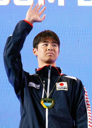 　男子２００メートル背泳ぎで優勝し、表彰式で歓声に応える小島夢貴（共同）