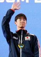 　男子２００メートル背泳ぎで優勝し、表彰式で歓声に応える小島夢貴（共同）
