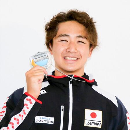 帰国し、メダルを手に笑顔を見せる今福和志