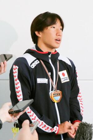 帰国し、取材に応じる大橋信