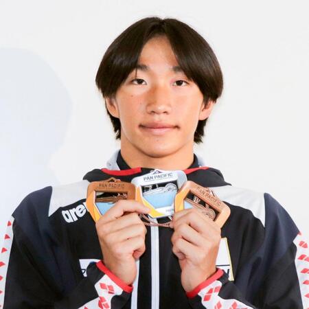 帰国し、メダルを手に写真に納まる大橋信