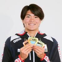帰国し、メダルを手に笑顔を見せる松下知之