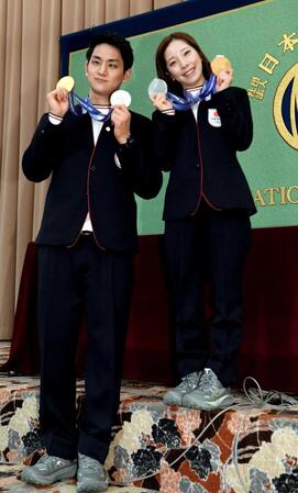 メダルを両手に笑顔を見せる木原龍一さん（左）と三浦璃来さん＝２月