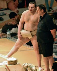 　大相撲夏巡業の朝稽古で師匠の安治川親方（右）と話す安青錦