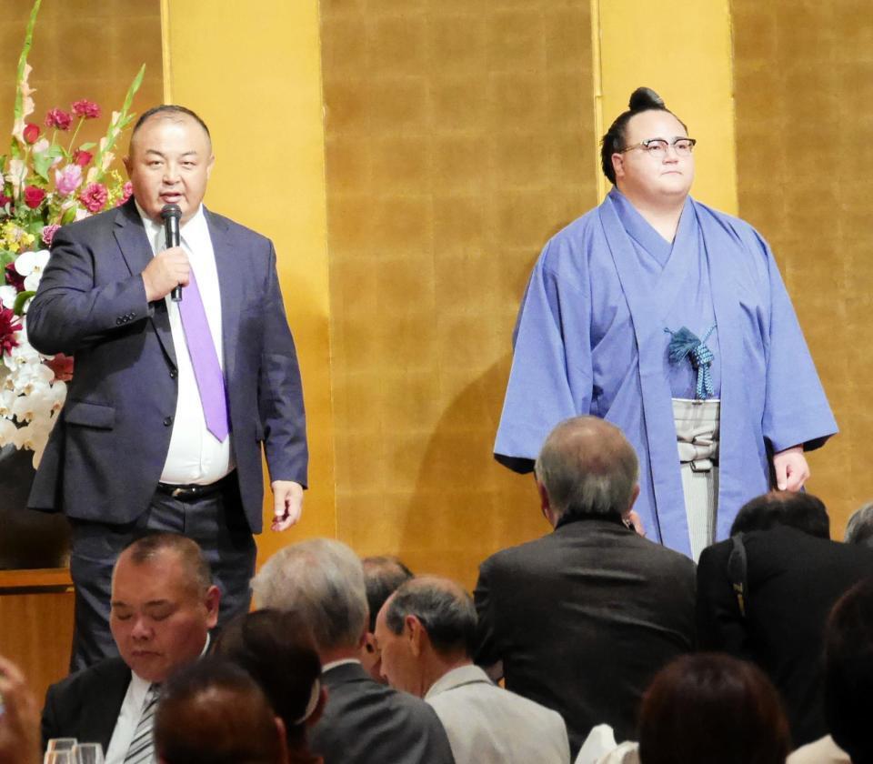 壇上であいさつする荒汐親方と丹治