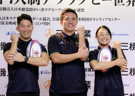 　ラグビーを表す手話で写真撮影に応じる、デフラグビー男子日本代表の（左から）大塚貴之と岸野楓＝東京都新宿区