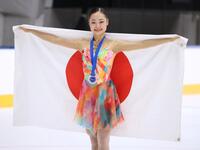 女子シングルで優勝し、日の丸を手に笑みを浮かべる島田麻央（撮影・伊藤笙子）