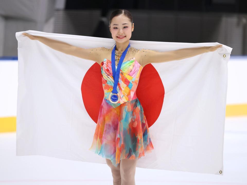 女子シングルで優勝し、日の丸を手に笑みを浮かべる島田麻央（撮影・伊藤笙子）