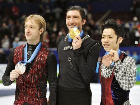 　２０１０年バンクーバー冬季五輪で銀メダルを受け取ったエフゲニー・プルシェンコ（左）。中央は金メダルのエバン・ライサチェク、右は銅メダルの高橋大輔＝パシフィックコロシアム（共同）