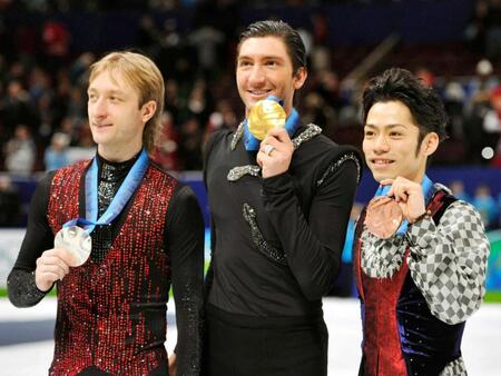 　２０１０年バンクーバー冬季五輪で銀メダルを受け取ったエフゲニー・プルシェンコ（左）。中央は金メダルのエバン・ライサチェク、右は銅メダルの高橋大輔（共同）