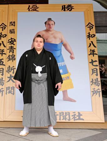 　贈呈された優勝額の前に立つ安青錦＝１２日、両国国技館