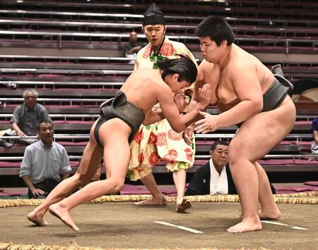 立ち合いで松の里（右）に頭からぶつかる新道（撮影・開出牧）